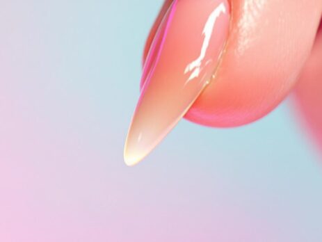 Gros plan sur un ongle long et brillant couleur rose pastel